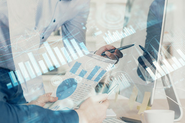 Double exposure of chart with businessman typing on computer in office on background. Concept of...