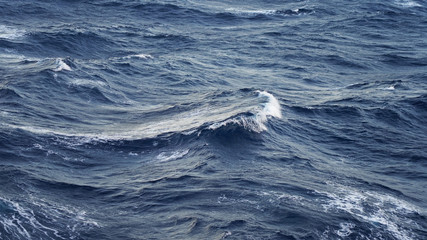 Sea ​​waves in the storm. dark blue water of the Pacific Ocean, white foam on the waves. pure salt water texture