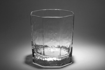 The whiskey glass is empty. Lighting from above.