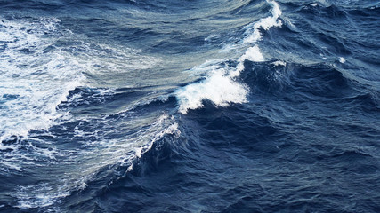 Sea ​​waves in the storm. dark blue water of the Pacific Ocean, white foam on the waves. pure salt water texture