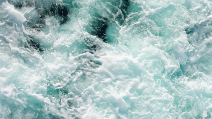 Fototapeta na wymiar Texture of marine splashes. crashing ocean wave foam structure. Dark blue clear water. Ocean depth.
