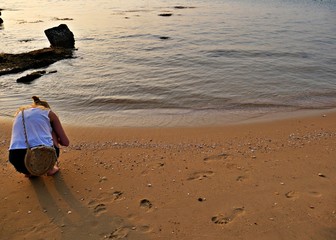 A girl looking for flotsam at a hidden beach