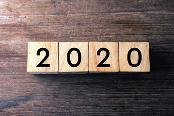 Top view text 2020 on wood cube which lay on wood table.