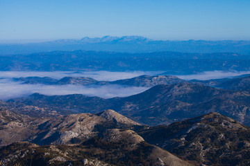  with blue misty mysterious mountains in the distance and an orange pastel sky. Distant blue mountains.