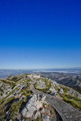 stone path,  road lined with slabs goes along a high pass to the observation deck, blue sky stones and grass summer-autumn landscape.