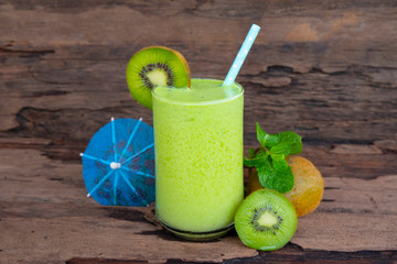 Kiwi yogurt fruit juice smoothie green colorful fruit juice milkshake blend beverage healthy high protein the taste yummy In glass drink episode morning on wood background.