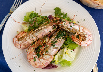 fried big shrimps with lettuce on white plate