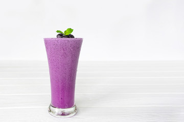 Blueberry Juice smoothies drink in a glass drink purple colorful fruit juice milkshake blend beverage healthy high protein the taste yummy in glass on white wood background.
