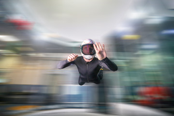 High. Man flies like a bird. Fly men in black suit. Extreme is a hobby for courage people. Air sport as a way of life.