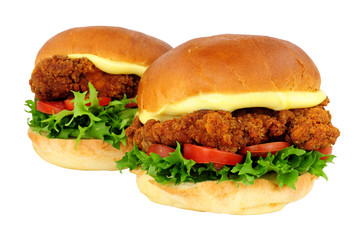 Southern fried chicken sandwiches with salad and mayonnaise in brioche bread rolls isolated on a white background