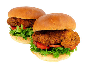 Southern fried chicken sandwiches with salad in brioche bread rolls isolated on a white background