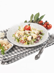 caesar salad with ham on a light plate on a white background isolated