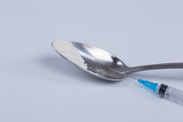 White pill, syringe and heroin on spoon. Drug addiction.