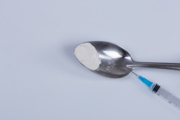 White pill, syringe and heroin on spoon. Drug addiction.