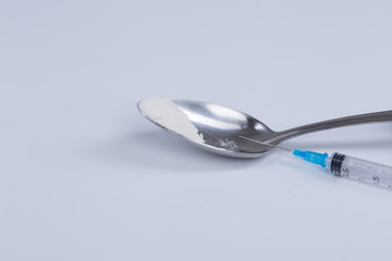 White pill, syringe and heroin on spoon. Drug addiction.