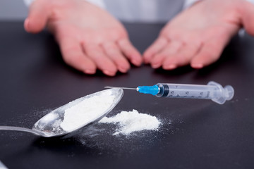 White pill, syringe and heroin on spoon. Drug addiction.