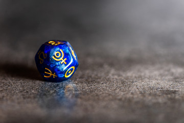 Blue Astrology Dice with symbol of the planet Pluto on grey background © manuta