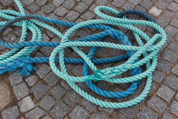 Blue and light blue ropes on stone ground