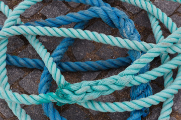 Blue and light blue ropes on stone ground