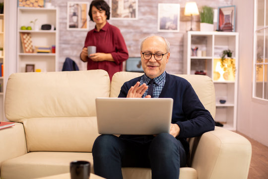 Elderly old couple using modern laptop to chat with their grandson