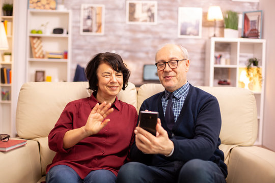 Old eldelry couple using a smartphone to talk with their family
