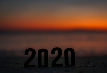 word 2020 on the beach at sunrise