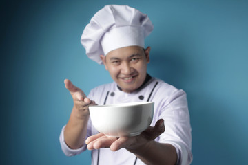 Asian Male Chef Shows Empty White Bowl, Presenting Something, Copy Space