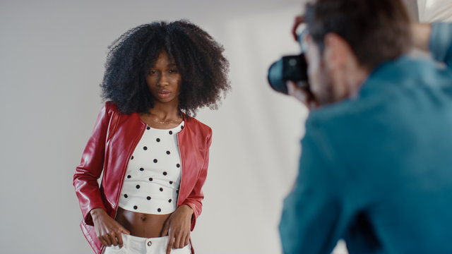 Behind the Scenes on Photo Shoot: Beautiful Black Model Posing for a Photographer, he Takes Photos with Professional Camera. Stylish Fashion Magazine Photoshoot done with Pro Equipment in a Studio