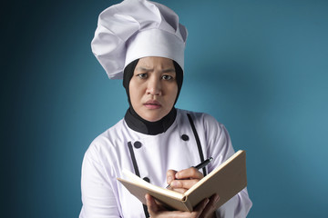 Woman Chef Reading Book of Recipes