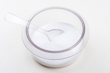 A cup of transparent plastic sugar and spoon