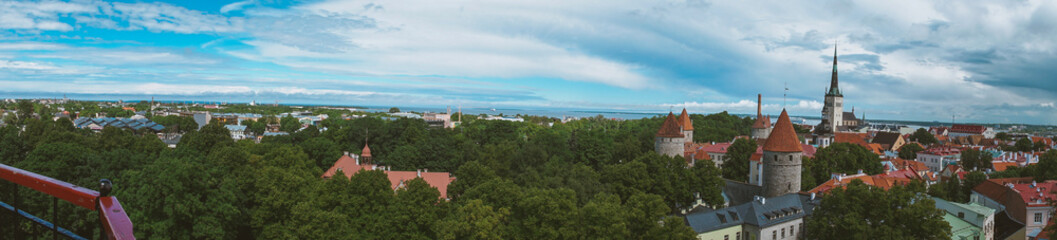 Fototapeta premium Aerial cityscape with medieval old town, St. Olav's Baptist church and Tallinn city wall in the morning, Tallinn, Estonia. Medieval walled city in the early autumn in the Baltic Sea region in Northern