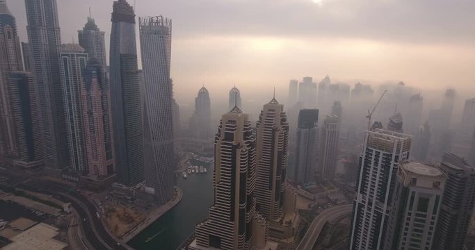 DUBAI, UAE - JANUARY 2, 2017: Aerial view of skyscrapers in Dubai Marina, at foggy sunrise. Dubai Marina is an artificial canal city, built along a two-mile (3 km) stretch of Persian Gulf shoreline.