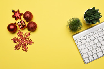Christmas decoration with computer keyboard on the yellow background with copy space