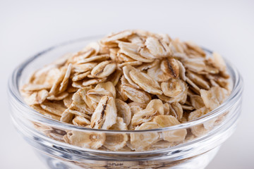 raw oat flakes on white acrylic background