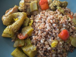 Top view on a plate full of buckwheat and stewed vegetables with duck meat