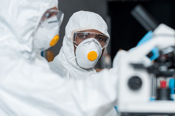 selective focus of african american scientist looking at his colleague