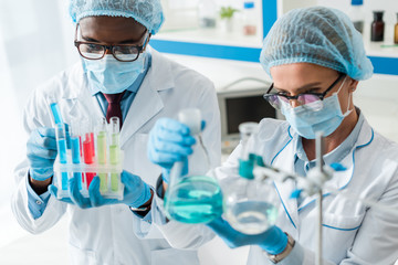 selective focus of multicultural biologists doing test in lab