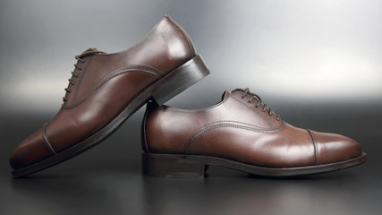 Classic men's brown Oxford shoes on dark background