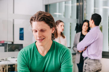 Fototapeta premium Close-up of smiling office worker with colleagues in background