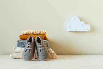 Organic cotton baby clothes and boots on the shelf