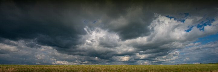 Fototapeta na wymiar Rainy clouds on sky background and field.