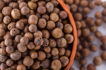 fresh spicy peppers allspice on white acrylic background