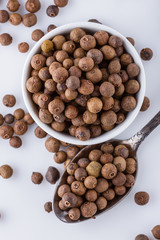 fresh spicy peppers allspice on white acrylic background