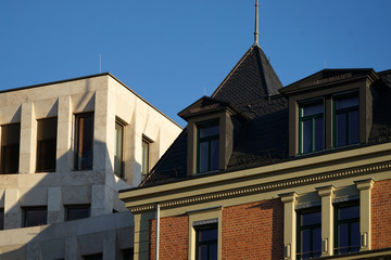 Fototapeta na wymiar Modernes Gebäude direkt neben einem historischen Wohnhaus im Stil des Klassizismus oder Jugendstils