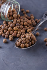 fresh spicy peppers allspice on a dark stone background