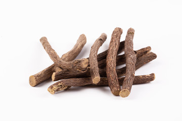 Macro closeup of a traditional sweet heap pile of Liquorice licorice wooden wood roots sticks spice isolated on white