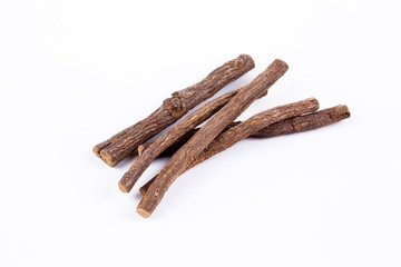 Macro closeup of a traditional sweet heap pile of Liquorice licorice wooden wood roots sticks spice isolated on white