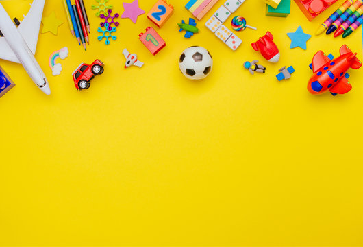 Frame of kids toys on yellow background with copy space