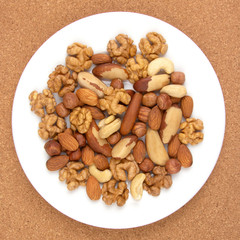 Different kinds of nuts on a white plate. Healthy and protein food.