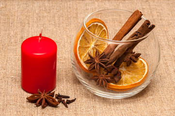 candle red and bowl with spices on linen cloth background.